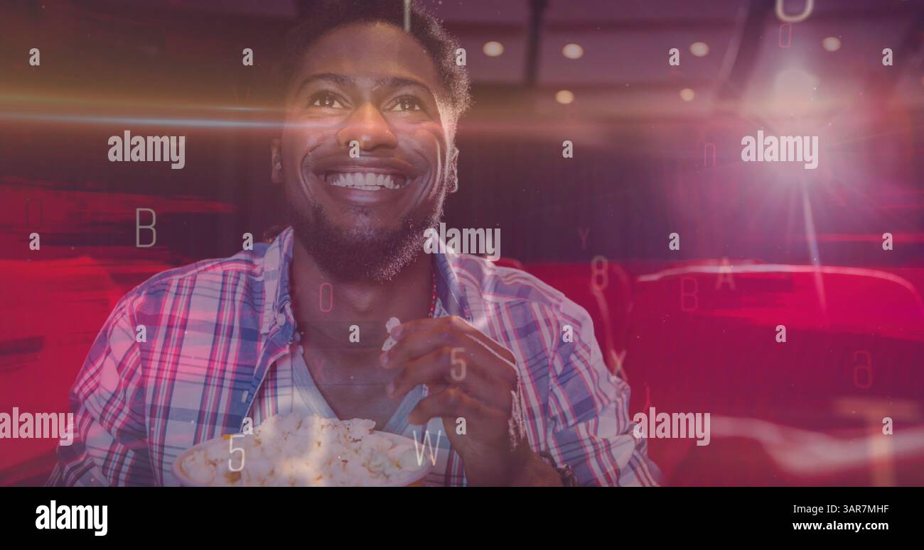 Bild von Briefen über lächelndem afroamerikaner, der Popcorn im Kino isst Stockfoto