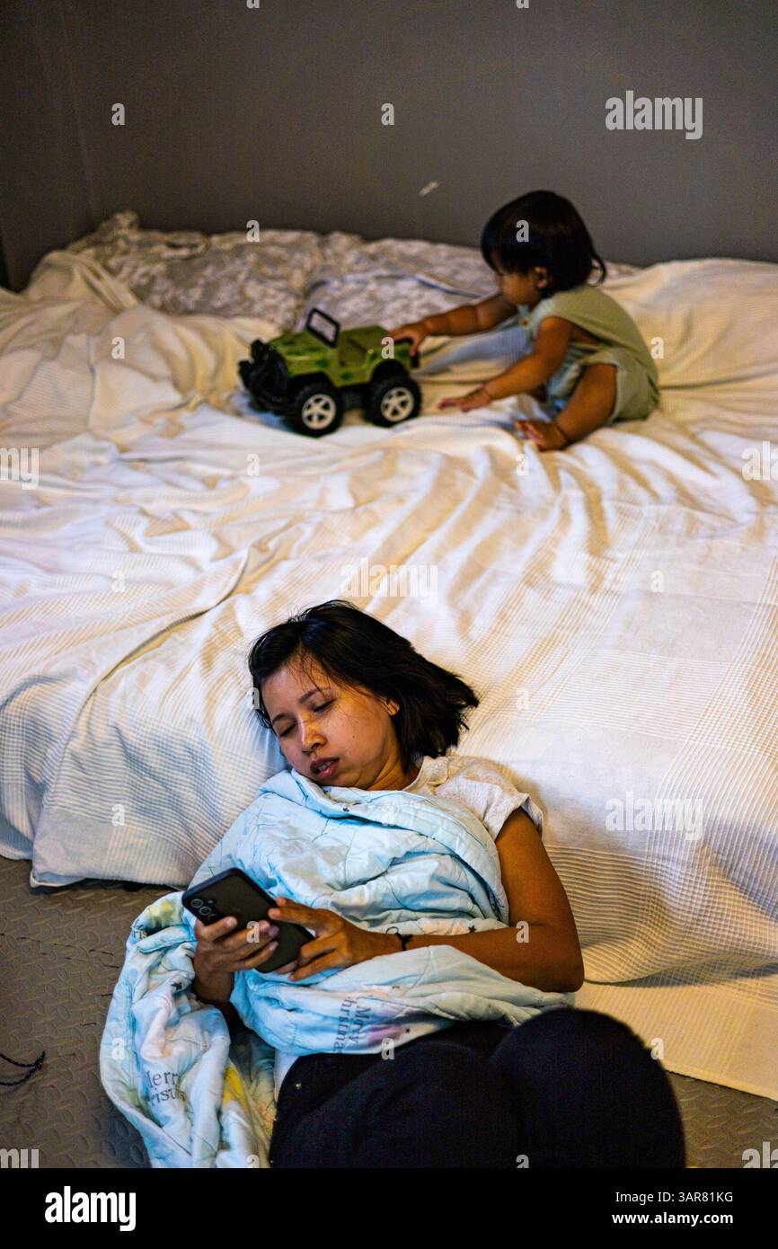 Mutter lag auf dem Boden, weil sie von der Betreuung des Kindes müde war, Hintergrund für Werbung und Tapeten in Relaxation und Lebensstil Stockfoto