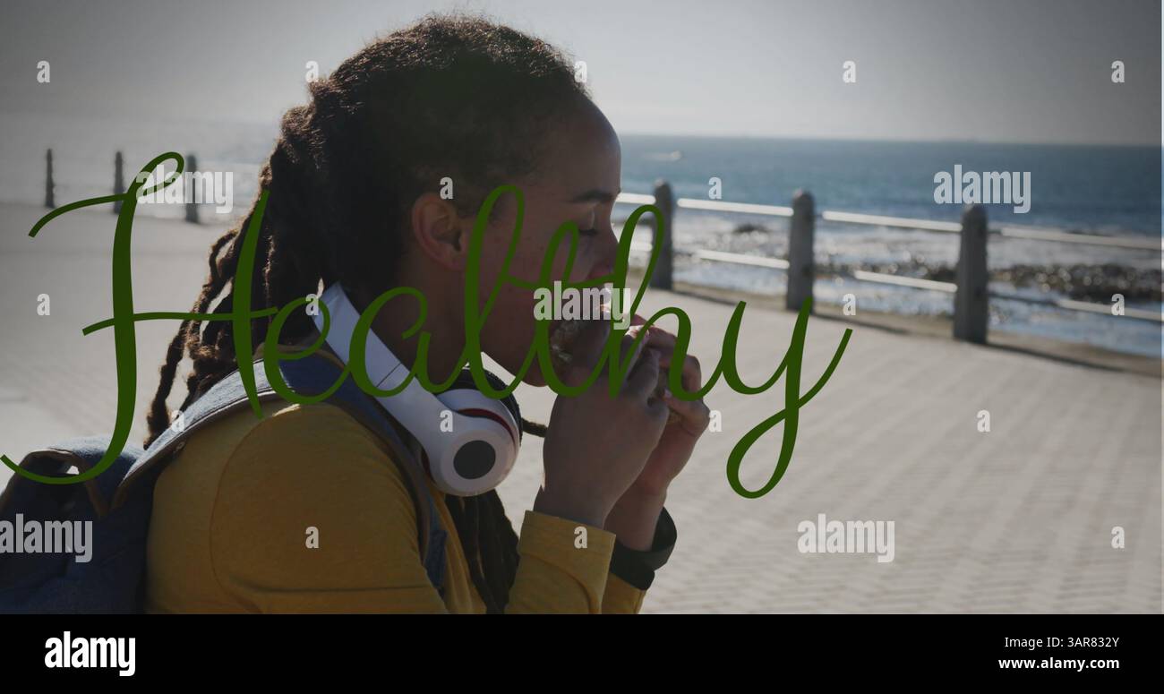 Gesundes Textbanner gegen afroamerikanische Frau, die einen Snack auf der Promenade hat Stockfoto