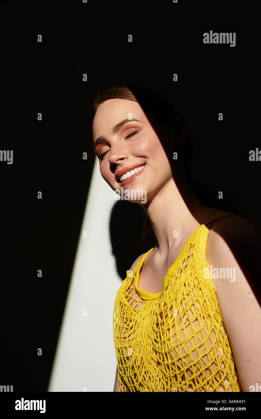 Die junge schöne Frau lächelt in einer lichtdurchfluteten Umgebung und zeigt ihre strahlende Energie. Stockfoto Die junge schöne Frau lächelt in einer lichtdurchfluteten Umgebung und zeigt ihre strahlende Energie. Stockfoto