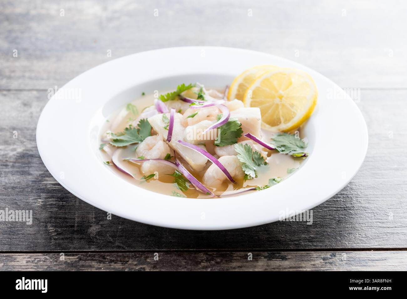 Traditionelles peruanisches Ceviche-Wolfsbarschfilet auf Holztisch Stockfoto