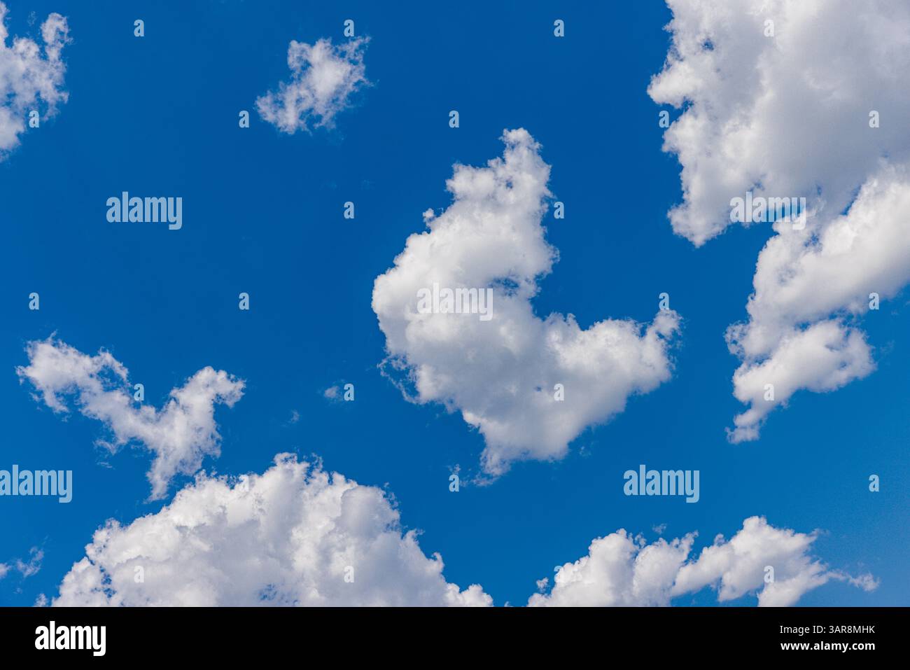 Sonniger Tag mit klarem blauem Himmel und weichen weißen Wolken, perfekt für friedliche Naturszenen, Outdoor-Hintergründe und helles Sommerwetter-Inspiration Stockfoto