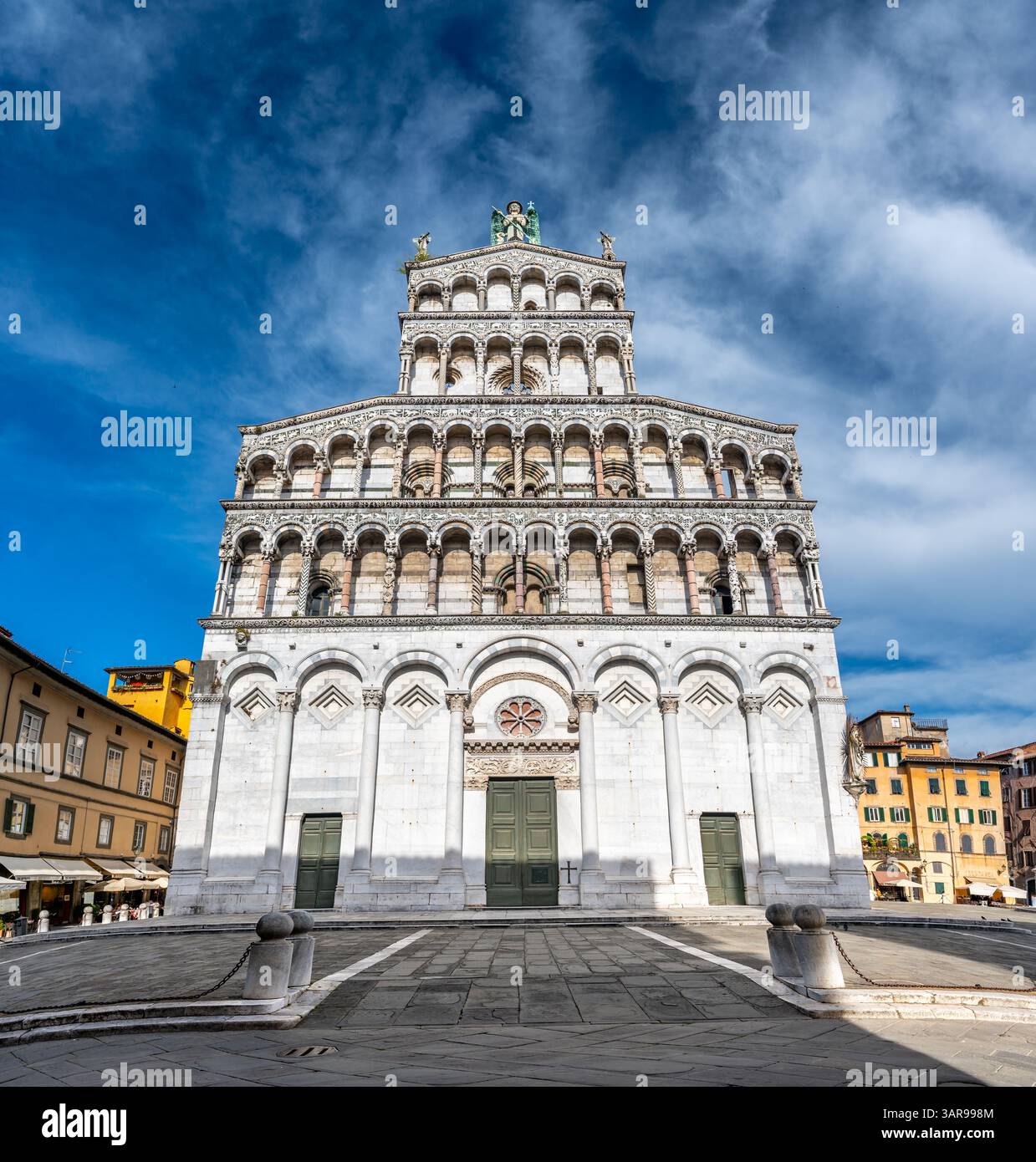 Panoramablick auf Chiesa di San Michele in Foro im historischen Zentrum von Lucca Italien an einem sonnigen Sommertag mit klarem blauem Himmel und warmem Licht auf dem Stockfoto
