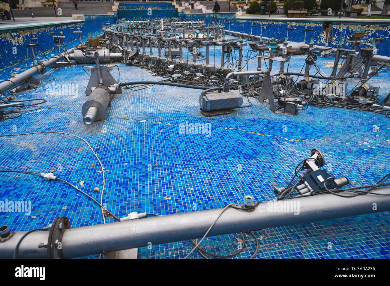 Deva, Rumänien - 11. April 2025 Leere Wasserbecken unter Wartung mit mobilen Düsen interaktive artesianische Springbrunnenpumpen Stockfoto