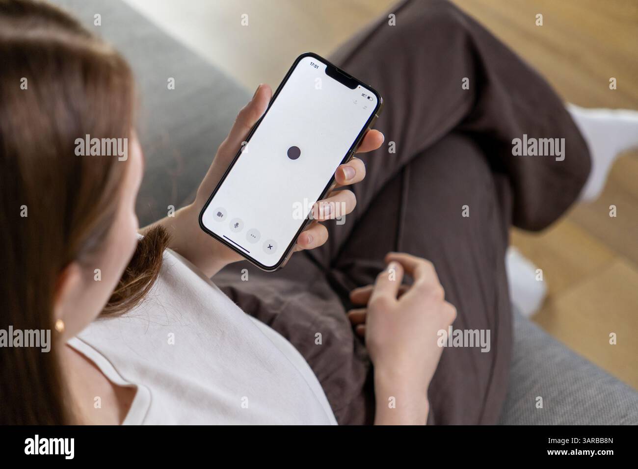 Posen, Polen – 14. April 2025: Eine Frau interagiert mit einer Assistentin der künstlichen Intelligenz auf ihrem Telefon über eine Spracheingabe mit Minimalist Stockfoto