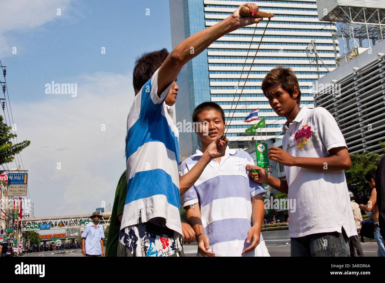 14. Mai 2010 - Bangkok, Thailand - Thailänder feuern mit Schleudern Steine und kleine selbstgemachte Sprengstoffe, die als Ping-Pong-Bomben bezeichnet werden, auf thailändische Truppen auf der Rama IV Rd. Ab Die thailändischen Sicherheitskräfte haben Live-Patronen abgefeuert, nachdem sie ein schwer verteidigtes Demonstrantenlager in Bangkok wegen Zusammenstößen, bei denen zwei Menschen getötet wurden, versiegeln wollten. Botschaften wurden geschlossen, als Demonstranten einen Polizeibus in Brand setzten und Feuerwerke auf Truppen schossen, die auch mit Tränengas und Gummigeschossen reagierten. Die Demonstranten wollen, dass der Premierminister zurücktritt und Wahlen ausruft. Viele der sogenannten Red-Shirt-Demonstranten unterstützen den ehemaligen Prime Mini Stockfoto