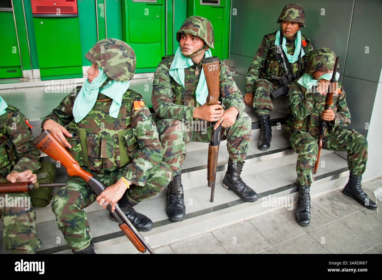 14. Mai 2010 - Bangkok, Thailand - thailändische Truppen ruhen sich aus, nachdem sie versucht haben, die Rama IV Rd in Bangkok von regierungsfeindlichen Demonstranten zu befreien. Die thailändischen Sicherheitskräfte haben Live-Patronen abgefeuert, nachdem sie ein schwer verteidigtes Demonstrantenlager in Bangkok wegen Zusammenstößen, bei denen zwei Menschen getötet wurden, versiegeln wollten. Botschaften wurden geschlossen, als Demonstranten einen Polizeibus in Brand setzten und Feuerwerke auf Truppen schossen, die auch mit Tränengas und Gummigeschossen reagierten. Die Demonstranten wollen, dass der Premierminister zurücktritt und Wahlen ausruft. Viele der sogenannten Roten-Hemd-Demonstranten unterstützen den ehemaligen Premierminister Thaksin Shinawatra, der o war Stockfoto