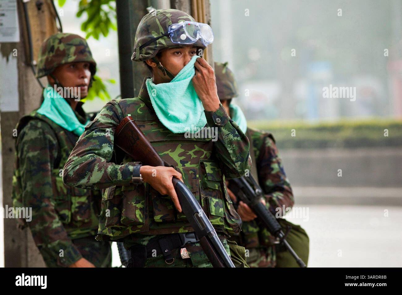 14. Mai 2010 - Bangkok, Thailand - Ein thailändischer Soldat wischt sich während einer Unterbrechung der Straßenproteste auf der Rama IV Rd. Das Gesicht Die thailändischen Sicherheitskräfte haben Live-Patronen abgefeuert, nachdem sie ein schwer verteidigtes Demonstrantenlager in Bangkok wegen Zusammenstößen, bei denen zwei Menschen getötet wurden, versiegeln wollten. Botschaften wurden geschlossen, als Demonstranten einen Polizeibus in Brand setzten und Feuerwerke auf Truppen schossen, die auch mit Tränengas und Gummigeschossen reagierten. Die Demonstranten wollen, dass der Premierminister zurücktritt und Wahlen ausruft. Viele der sogenannten Red-Shirt-Demonstranten unterstützen den ehemaligen Premierminister Thaksin Shinawatra, der in einem 20er-Rennen gestürzt wurde Stockfoto