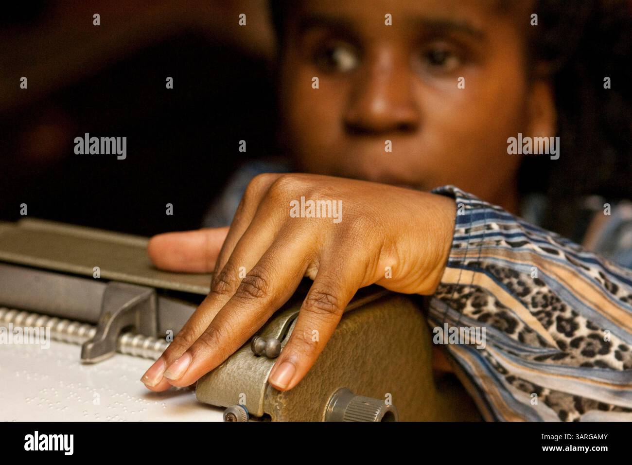 Februar 2010 - Tampa, Florida, USA - WILLIE J. ALLEN JR. | Zeiten . TP  318736 ALLE Braille.(15.02.2010 Tampa) Denisha Kirnes, 15, (cq) Proof liest die Wörter, die sie auf ihrer brailleschriftmaschine kurz zuvor in ihrem Haus in Tampa am Montag eingegeben hat. Die sehbehinderte Kirnes verwendet eine brailleschrift, die sie liebevoll ihren 10-Pfund-Bleistift nennt, um ihre Hausaufgaben zu erledigen und Etiketten für ihr Zuhause zu machen. Kirnes, der eine Augenprothese hat und das andere Schatten und helle Farben sieht, plant, Anwalt zu werden. Sie lernte blindenschrift im Kindergarten und wird an der Braille Challenge teilnehmen Stockfoto