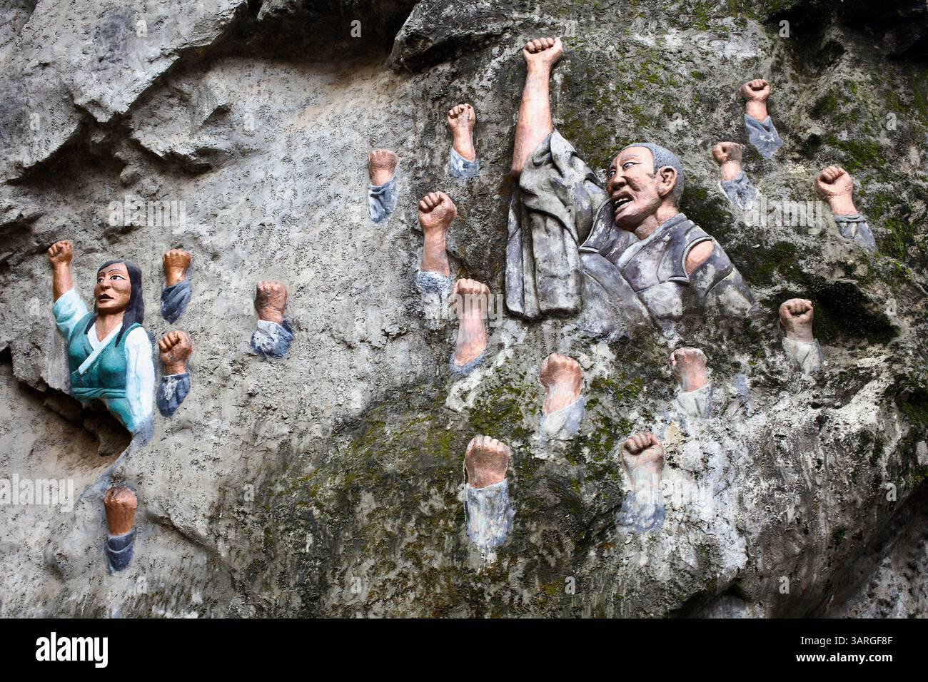 BAS-Relief mit erhobenen Fäusten und tibetischen Figuren, die den Widerstand hinter dem National Martyrs’ Memorial in Dharamshala, Himachal Pradesh, Indien, symbolisieren. Stockfoto