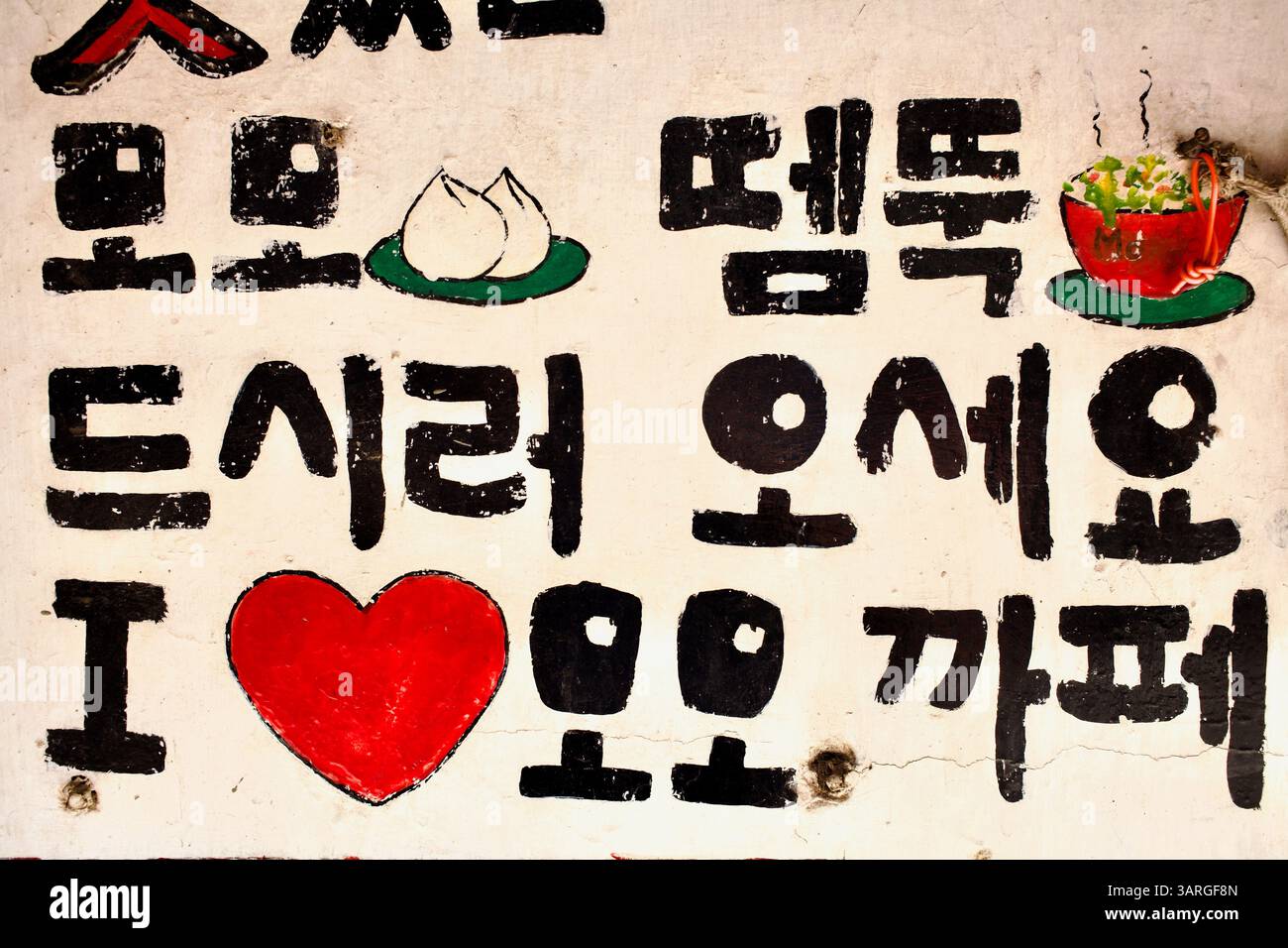 Handgemaltes koreanisches Schild für ein Momo Café mit Illustrationen für Knödel und Suppen, das visuelles Spiel mit Werbung für Street Food verbindet. Stockfoto