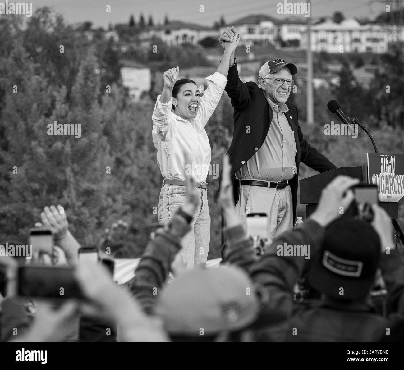 B&W von Bernie Sanders und Alexandria Ocasio-Cortez winken am Ende einer Kundgebung am Folsom Lake College auf der kämpfenden Oligarchie-Tour zusammen. Stockfoto