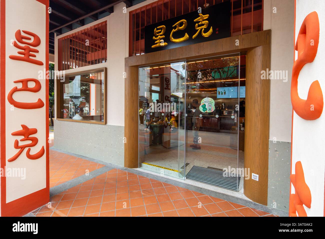 Starbucks Outlet-Eingang, Xing Ba Ke in chinesischen Worten auf die architektonische Säule und Beschilderung gemeißelt. Leute drinnen, um Kaffee zu trinken. Chinatown, Singapur. Stockfoto