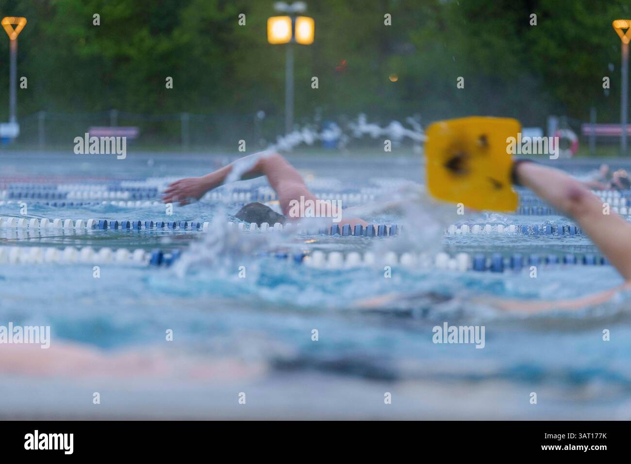 18. April 2025, Hessen, Frankfurt/Main: Frühschwimmerinnen und Frühschwimmerinnen machen kurz nach Sonnenaufgang ihre Bahnen im Hausen Freibad. Hausen Freibad war das erste Freibad Frankfurts, das am Karfreitag für die Sommersaison geöffnet hat. Der Außenbereich kann täglich vom 18. April von 6,30 bis 20 Uhr genutzt werden. Foto: Andreas Arnold/dpa Stockfoto