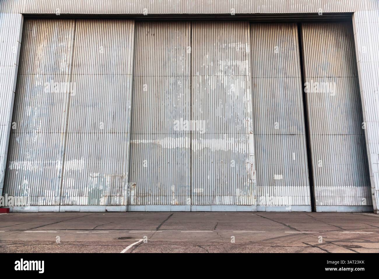Die Fassade eines großen Metallhangars mit einem Tor. Stockfoto