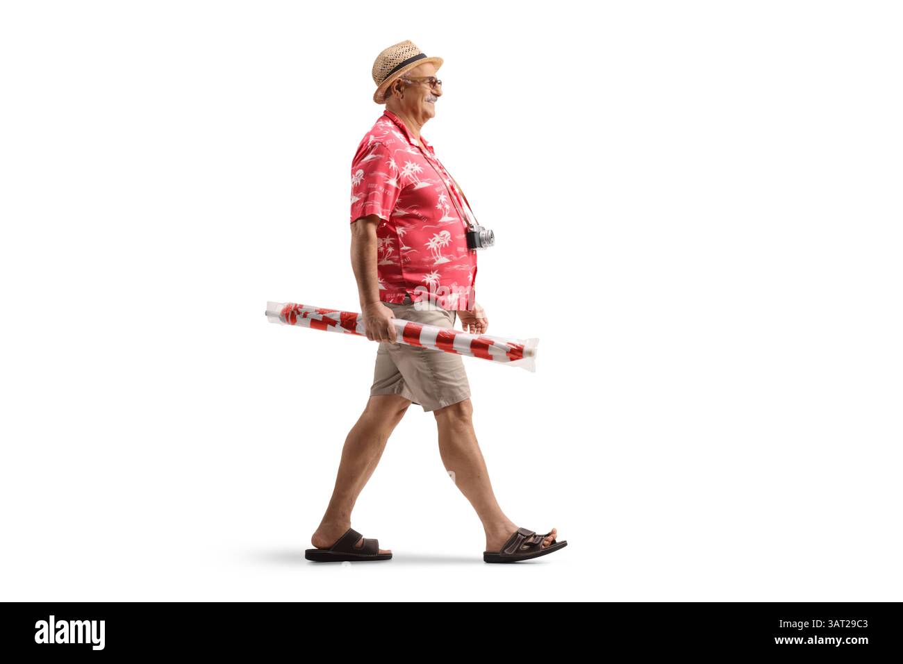Männlicher Tourist, der einen Sonnenschirm hält und isoliert auf weißem Hintergrund läuft Stockfoto