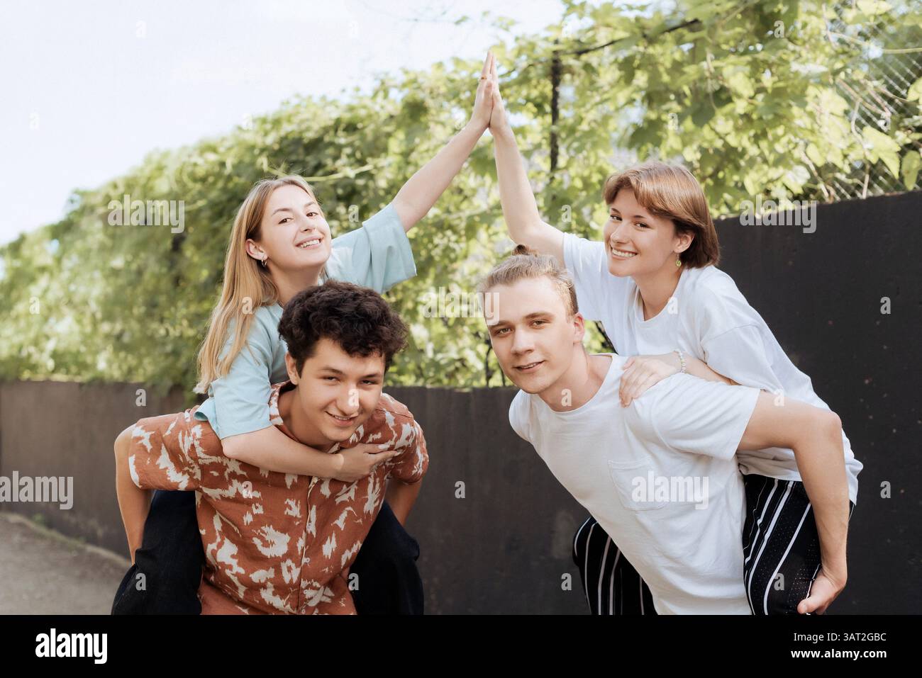 Freunde geben im Freien High-Five in spielerischer Stimmung Stockfoto