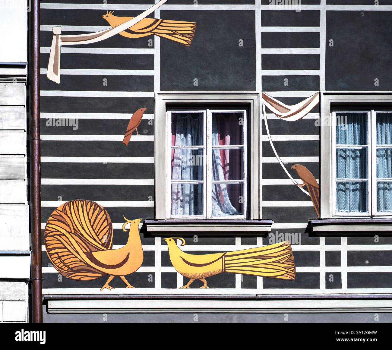 Ein farbenfrohes Wandbild in einem Gebäude mit stilisierten Vögeln und abstrakten Formen. Das Design umfasst zwei gelbe Vögel, einen braunen Vogel und dekorative Elemen Stockfoto
