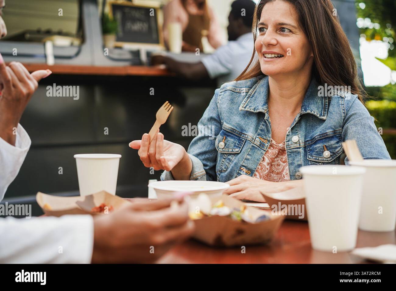 Frau aus den 50er Jahren isst im Food Truck Restaurant im Freien - Frühlings-Lifestyle und Dinner-Konzept - Fokus auf weibliches Gesicht Stockfoto