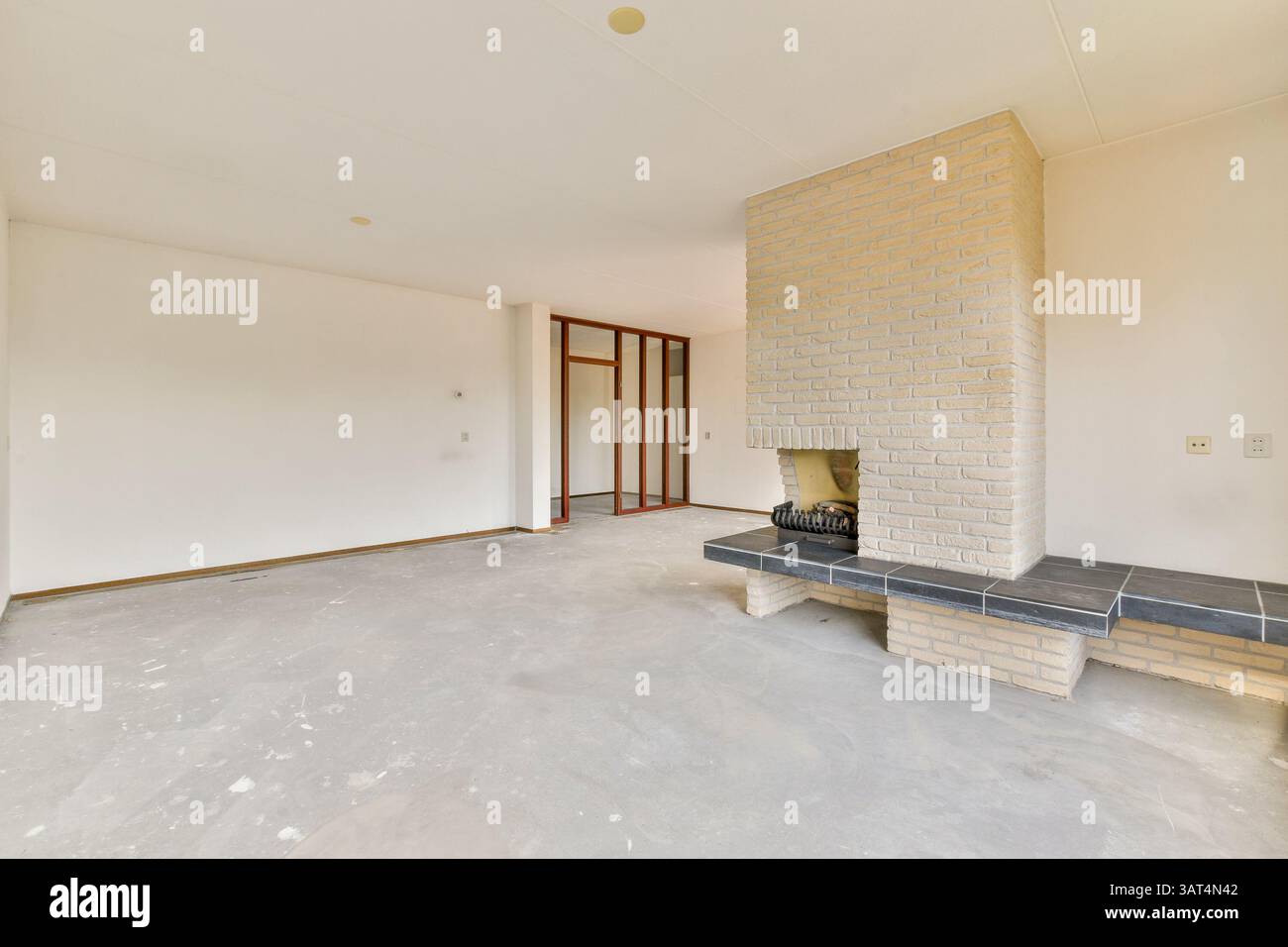 Ein hell eingerichtetes Wohnzimmer mit modernem minimalistischem Ästhetik, gemauertem Kamin und Wänden in neutralen Farben. Ideal für moderne Wohndesigns. Stockfoto