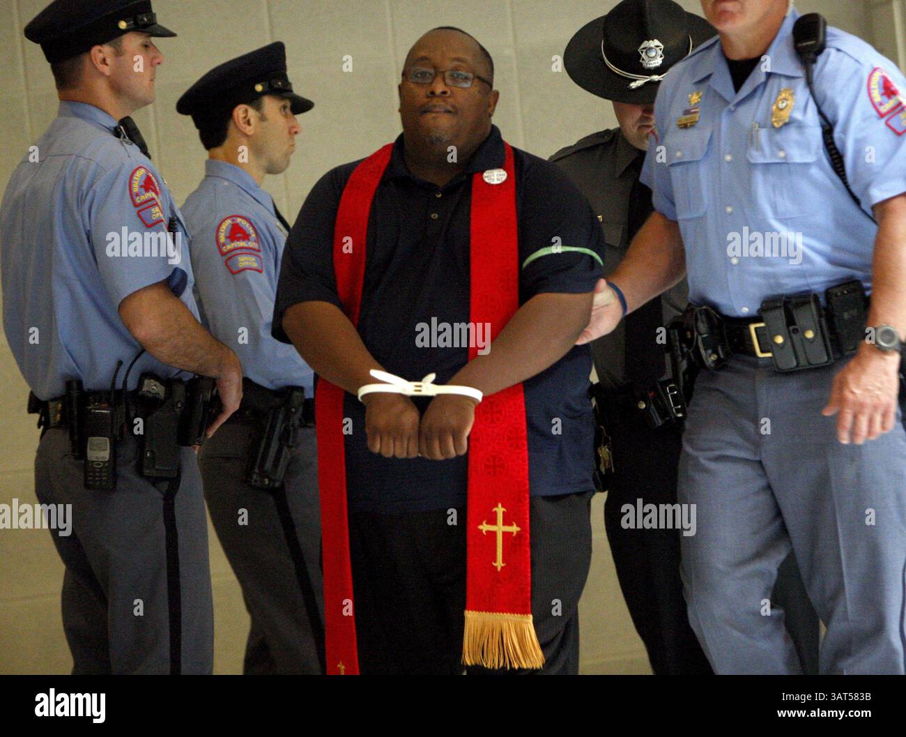 10. Juni 2013 – Raleigh, NC, USA – Ein Mitglied des Klerus ist unter Dutzenden von Demonstranten, die während eines Aktes des zivilen Ungehorsams gegen die Tagesordnung der Republikanischen Legislative am Montag, 10. Juni 2013, im North Carolina State Legislative Building von Raleigh und der Polizei der Generalversammlung in Raleigh, North Carolina, verhaftet wurden. Seit Beginn der Demonstrationen am 29. April wurden mehr als 300 Menschen verhaftet. (Kreditbild: © Travis Long/MCT/ZUMAPRESS.com) Stockfoto
