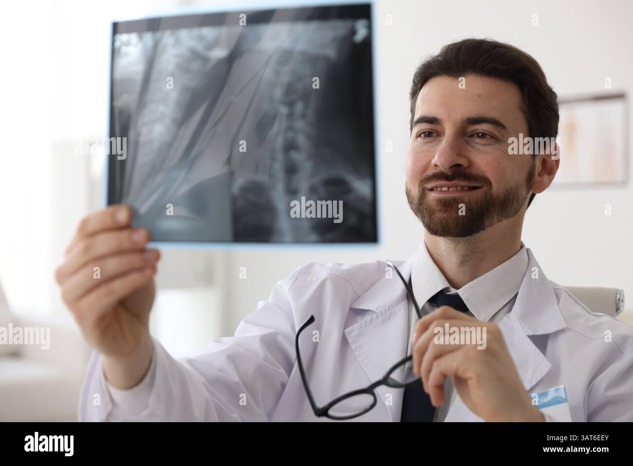Lächelnder Arzt untersucht Hals-MRT in der Klinik Stockfoto