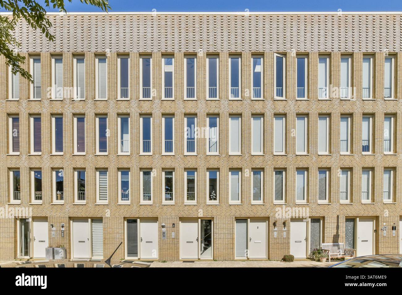 Eine optisch eindrucksvolle Fassade eines modernen architektonischen Gebäudes mit einer Reihe sich wiederholender Fenster und einer zeitgenössischen Design-Ästhetik. Stockfoto