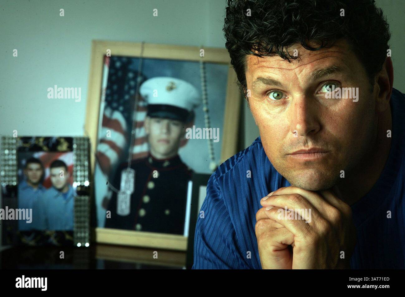 Mai 2005; Hollywood, FL, USA; CARLOS ARREDONDO aus Hollywood, Florida, neben der Ausstellung in seinem Wohnzimmer, die er von seinem Sohn machte, der 2004 im Irak getötet wurde. Carlos war in seinem Vorgarten und baute einen neuen weißen pickett-Zaun auf, als ein Marinemobil zu seinem Haus fuhr, um ihm mitzuteilen, dass sein 20-jähriger Sohn Alexander Scott Arredondo im Irak durch eine Scharfschützenkugel getötet wurde. Carlos zündete den Militärwagen an, zerstörte das Fahrzeug und verbrannte sich bei dem Vorfall. Heute stehen Carlos und seine 65-jährige Mutter Luz Marina Arredondo unter psychiatrischer Betreuung, um mit Alexanders umzugehen Stockfoto