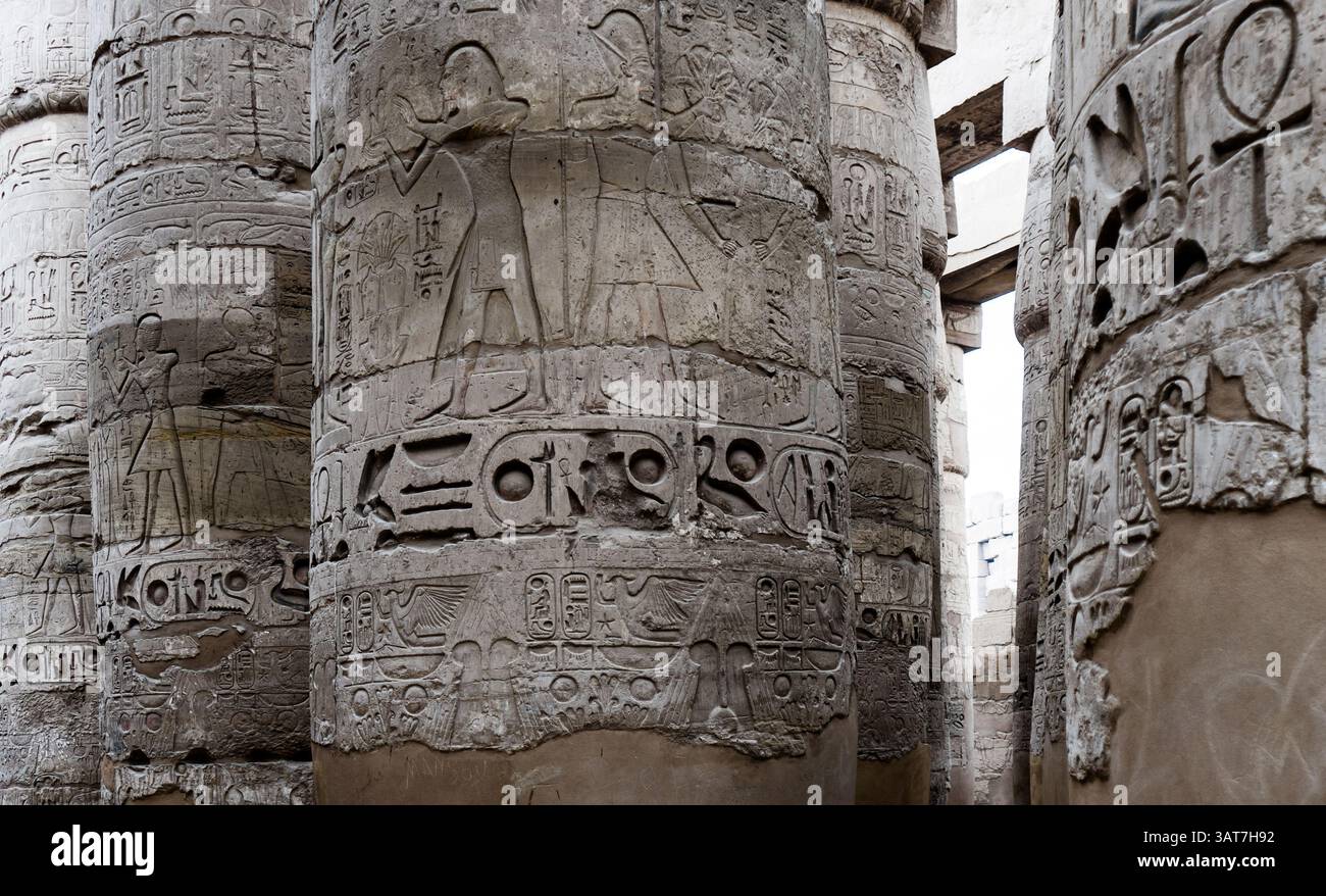 Antike ägyptische Säulen, die mit komplexen Hieroglyphen verziert sind und historische Schnitzereien und Symbole in einer Tempelanlage zeigen. Stockfoto Antike ägyptische Säulen, die mit komplexen Hieroglyphen verziert sind und historische Schnitzereien und Symbole in einer Tempelanlage zeigen. Stockfoto