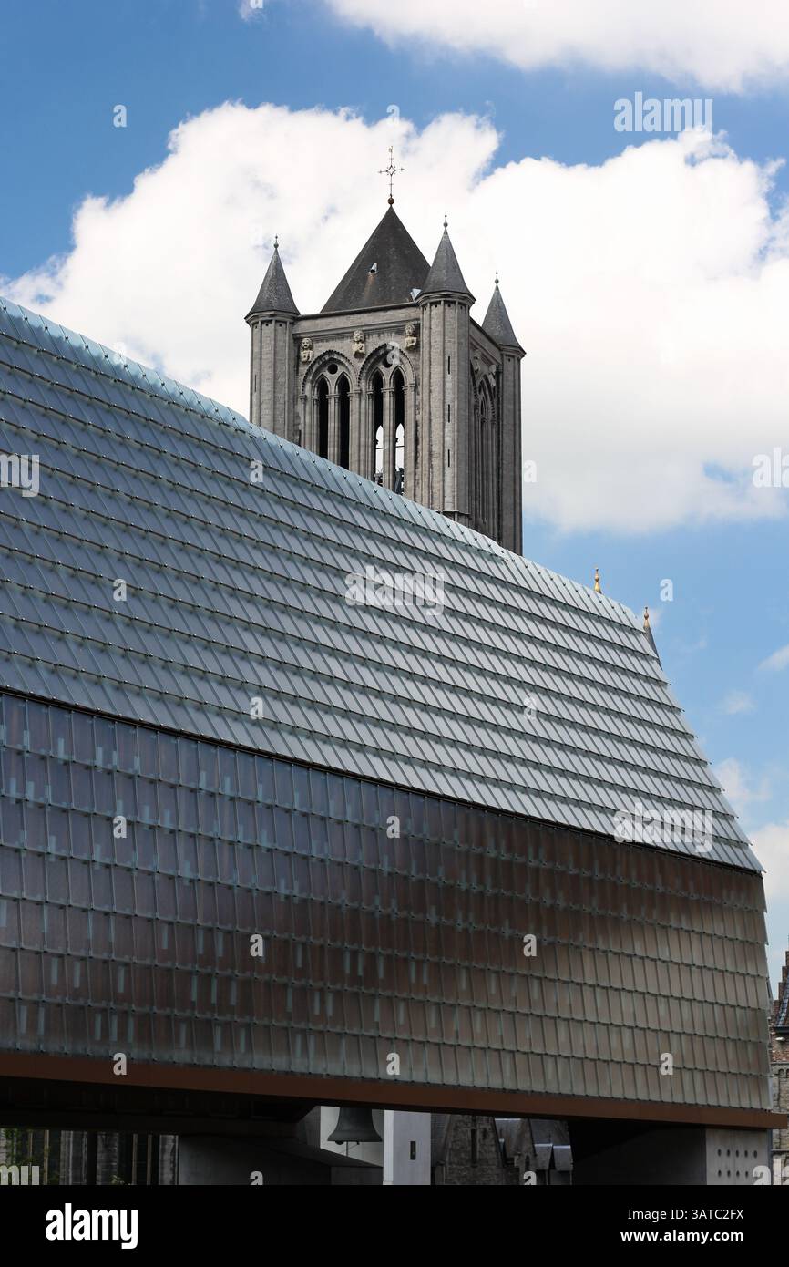 Ein architektonisches Foto, das einen historischen Glockenturm gegenüber einem modernen Gebäude zeigt und die Schönheit des architektonischen Kontrastes unterstreicht Stockfoto