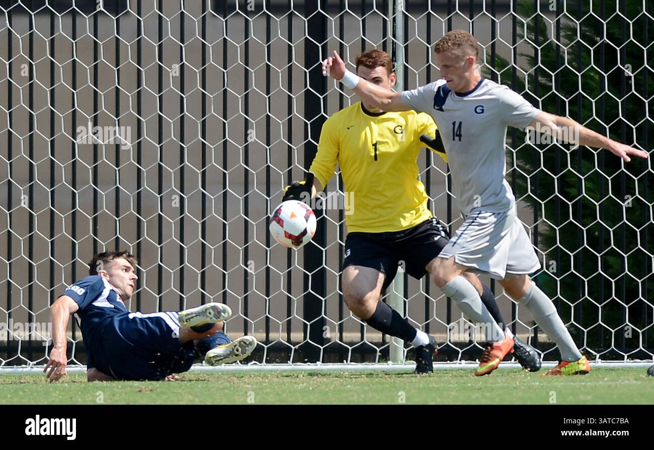 13. September 2013 – Washington, DC, USA – Duquesne-Mittelfeldspieler Austin lange (21), links, versucht auf dem Spielfeld einen Schuss gegen Georgetown-Torhüter Tomas Gomez (1) und Georgetown-Verteidiger Cole Seiler (14) während der ersten Halbzeit im Shaw Field auf dem Georgetown Campus in Washington, D.C. am Freitag, 13. September 2013. Georgetown besiegte Duquesne mit 1:0. (Kreditbild: © Chuck Myers/MCT/ZUMAPRESS.com) Stockfoto
