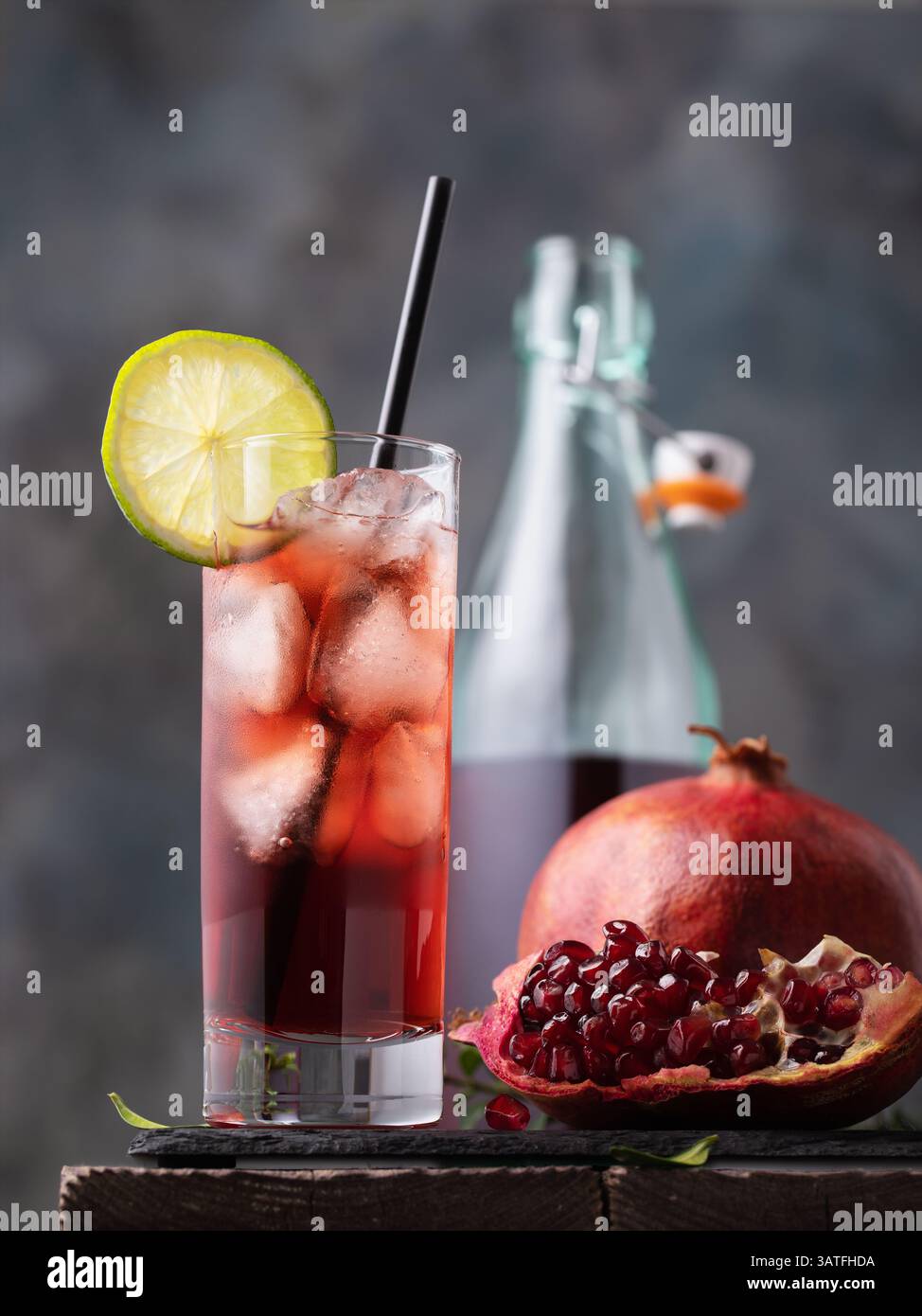 Granatapfelsaft mit Eis im Glas und Obst auf dem Tisch Stockfoto