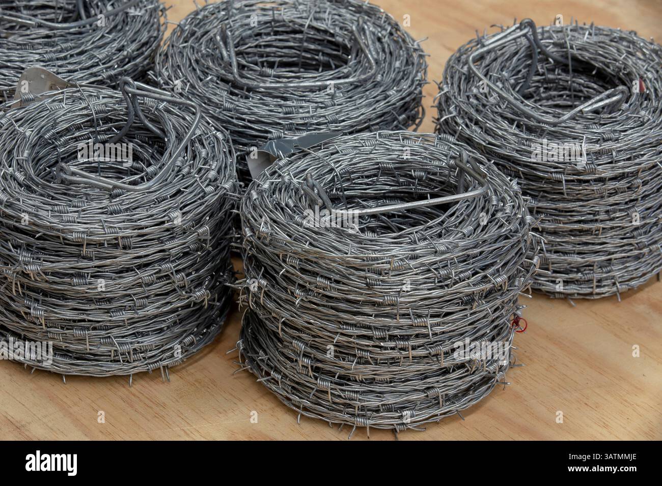 Nahaufnahme einer Stapelrolle aus glänzendem neuem Stacheldraht. Stockfoto