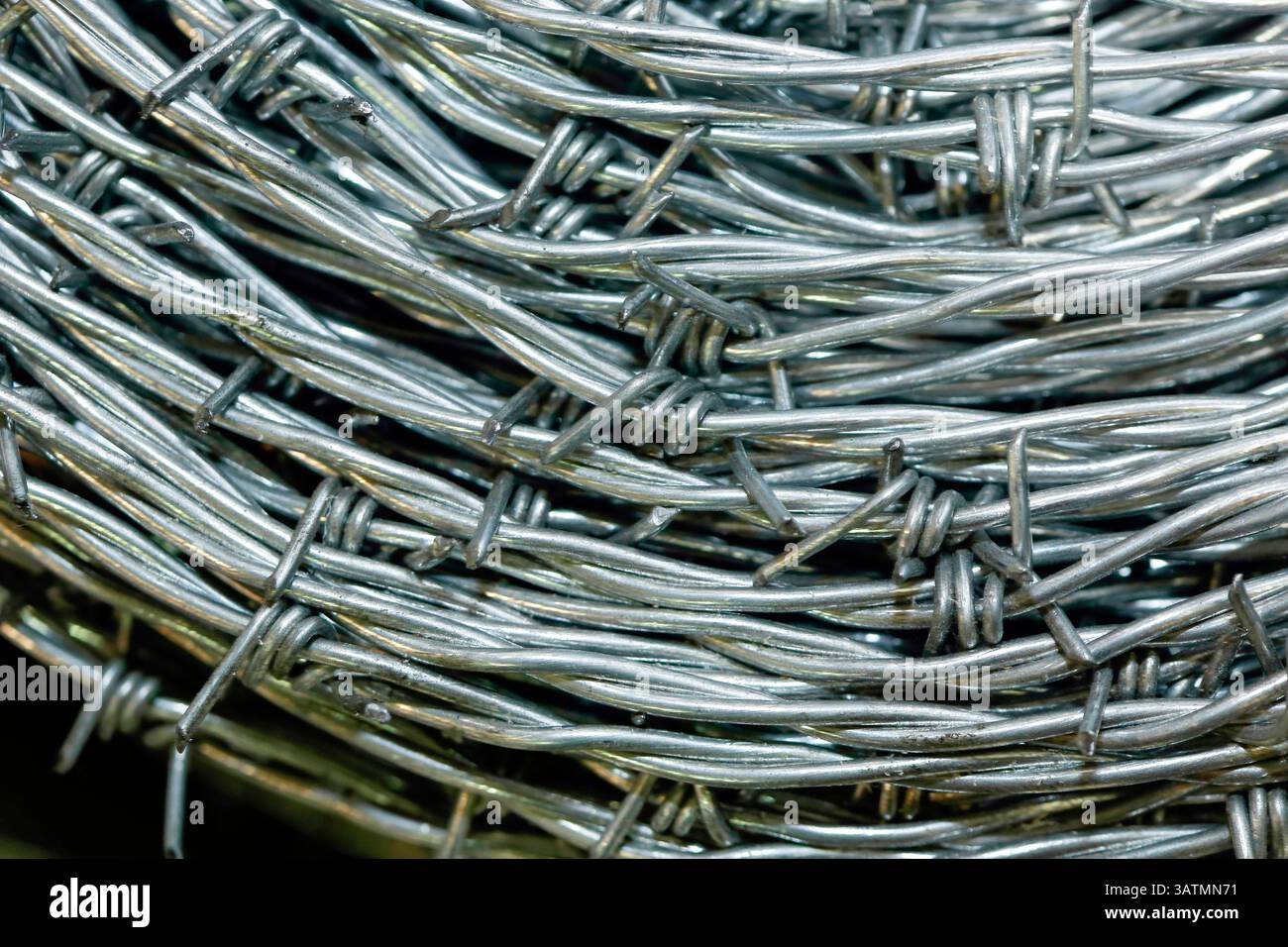 Nahaufnahme einer Stapelrolle aus glänzendem neuem Stacheldraht. Stockfoto