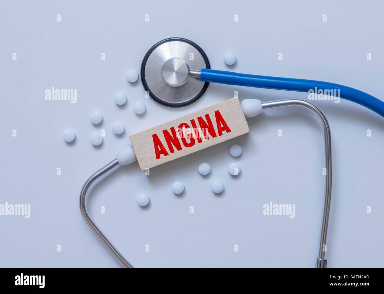 Holzblock aus dem Wort Angina mit Stethoskop auf dem Schreibtisch des Arztes. Medizinisches Konzept. Gesundheitskonzept für Krankenhaus, Klinik und medizinische Bu Stockfoto