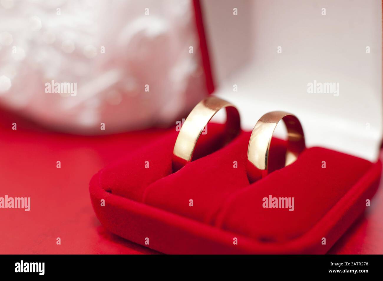 Zwei goldene Eheringe in einer roten Samtbox, Makro Stockfoto