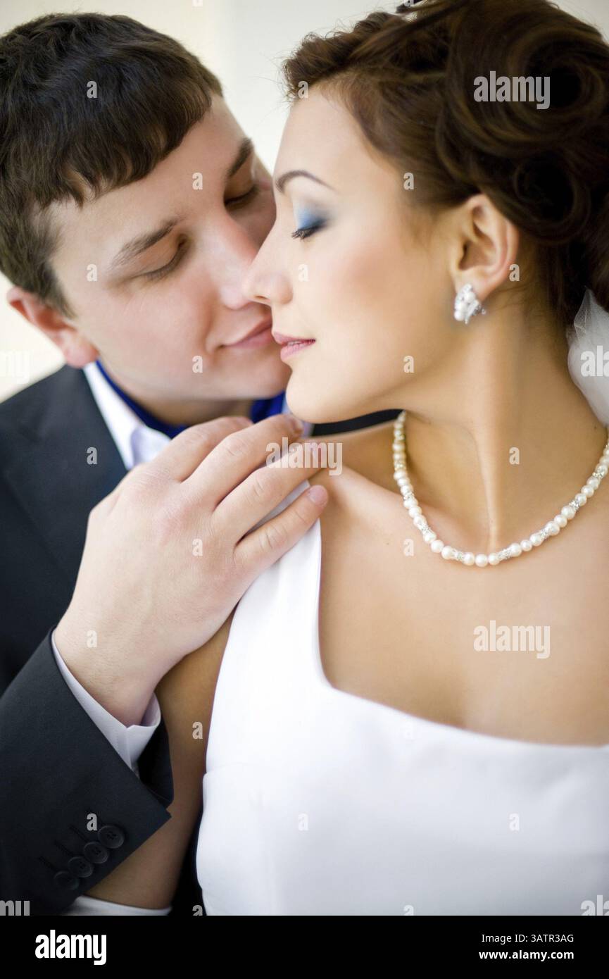 Ein Bräutigam umarmt seine Braut, am Hochzeitstag Stockfoto
