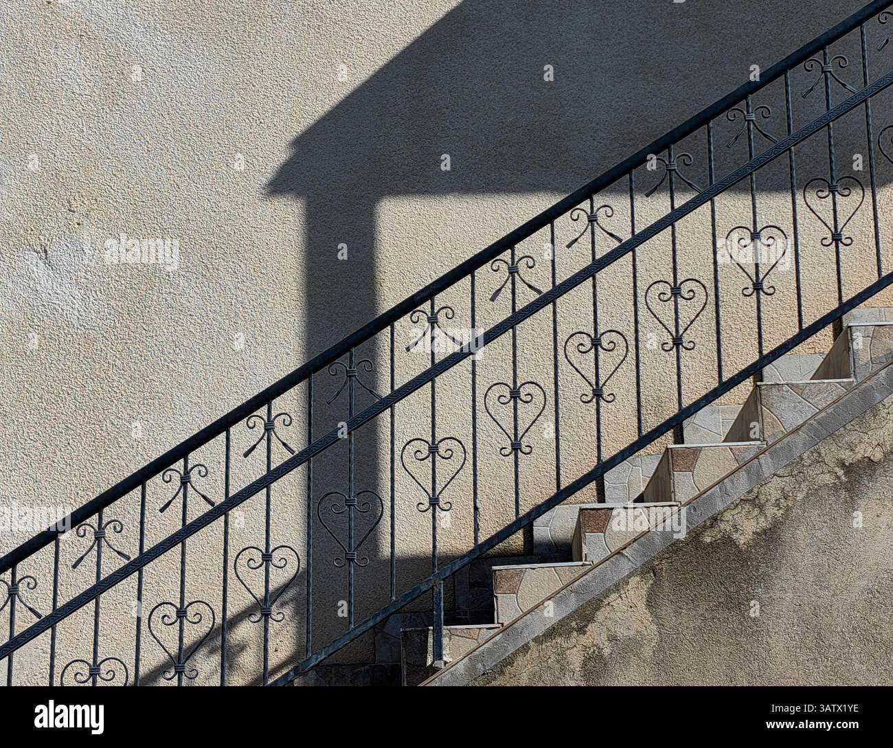Geschmiedete Leuchte. Städtische Symmetrie. Teil der Hauswand außen, Architektur. Stockfoto