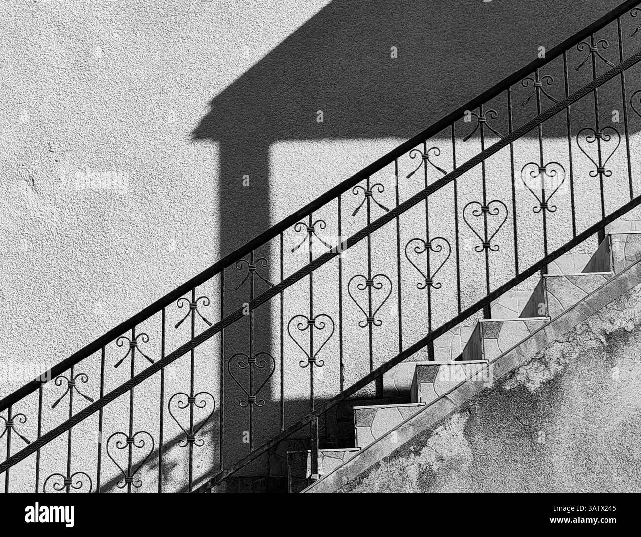 Geschmiedete Leuchte. Städtische Symmetrie. Teil der Hauswand außen, Architektur. Stockfoto