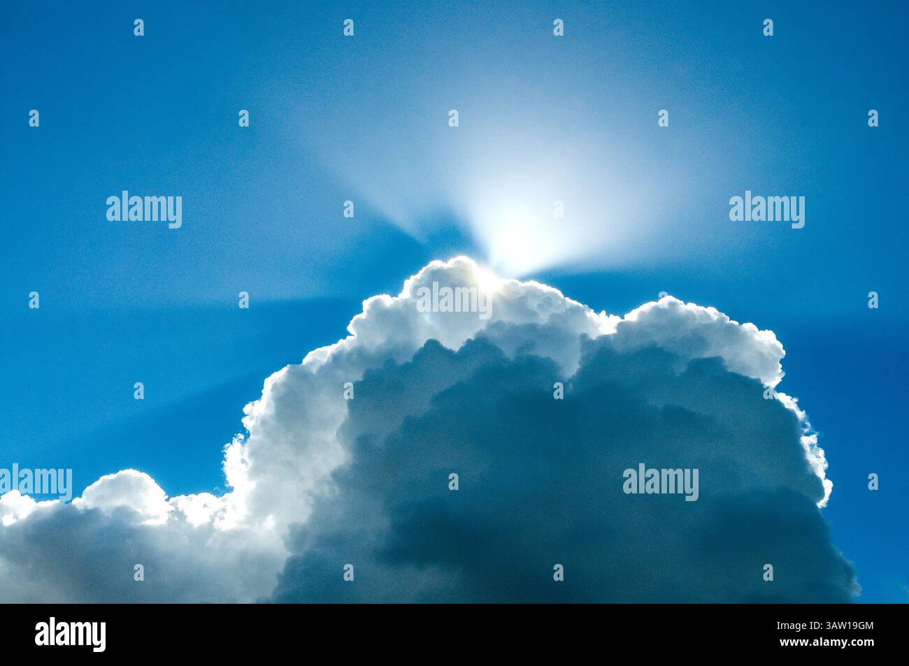 Sonnenstrahlen, die über Cumulus erscheinen und sich in Cumulonimbus-Wolken verwandeln - Zentralfrankreich. Stockfoto