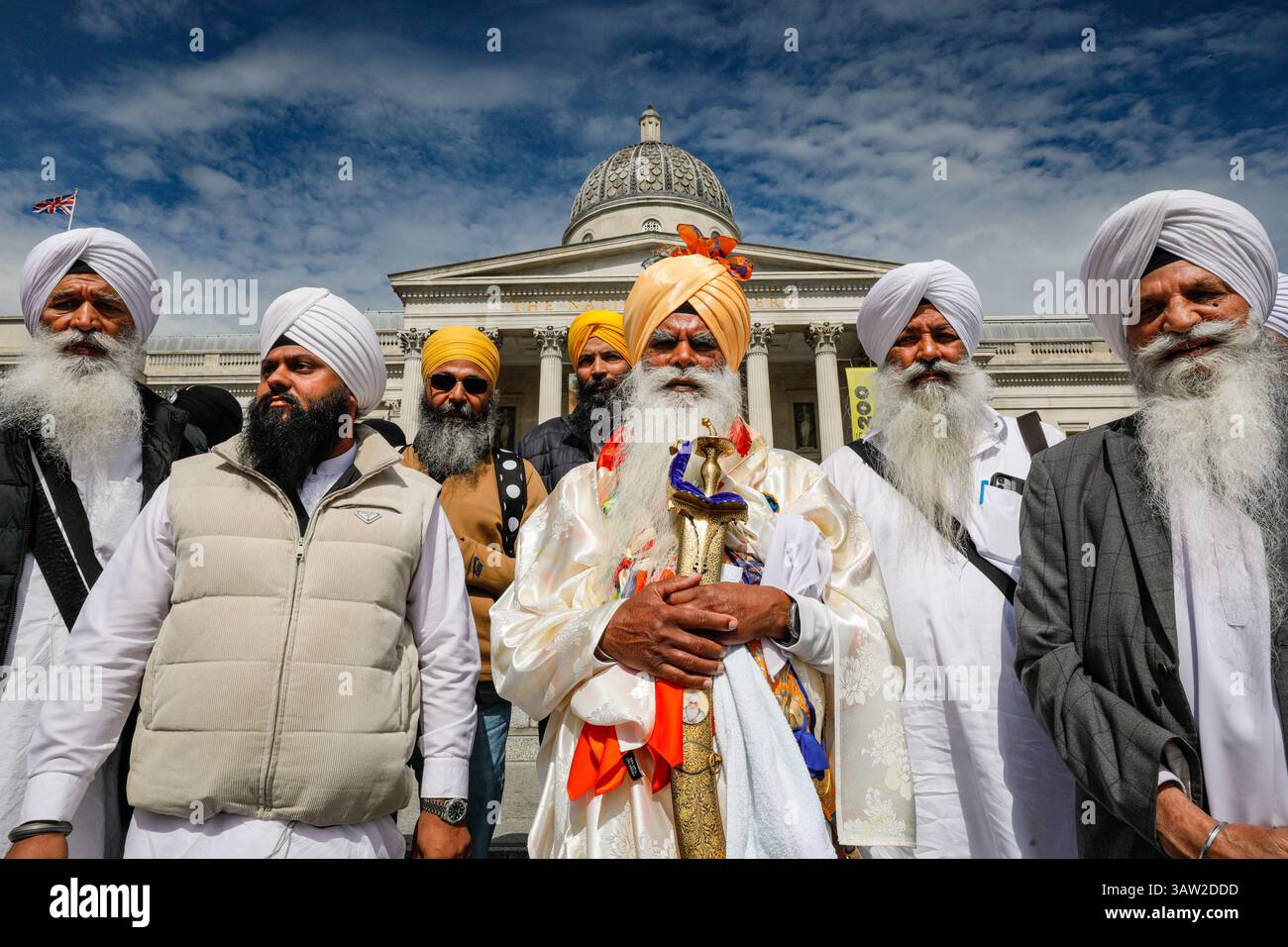 London, Großbritannien. April 2025. Eine Gruppe in traditioneller Sikh-Kleidung und traditionellen Accessoires wie dem Kirpan (Schwert oder Dolch) und kara (Stahlarmband) eröffnen das Festival mit einer Parade um den Platz und einem kurzen Gebet auf den Stufen vor der Nationalgalerie. Das Vaisakhi Festival, eine Feier der Sikh-Kultur und des Kulturerbes, wird mit Aufführungen, Musik, Essen, Gemeinschaftsaktivitäten und Freude für alle am Trafalgar Square gefeiert. Vaisakhi ist eines der wichtigsten Termine im Sikh-Kalender und wird weltweit gefeiert. Quelle: Imageplotter/Alamy Live News Stockfoto