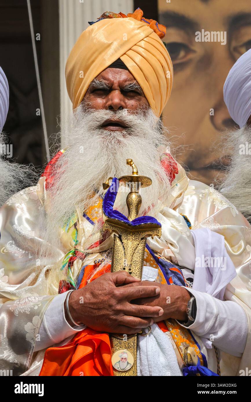 London, Großbritannien. April 2025. Eine Gruppe in traditioneller Sikh-Kleidung und traditionellen Accessoires wie dem Kirpan (Schwert oder Dolch) und kara (Stahlarmband) eröffnen das Festival mit einer Parade um den Platz und einem kurzen Gebet auf den Stufen vor der Nationalgalerie. Das Vaisakhi Festival, eine Feier der Sikh-Kultur und des Kulturerbes, wird mit Aufführungen, Musik, Essen, Gemeinschaftsaktivitäten und Freude für alle am Trafalgar Square gefeiert. Vaisakhi ist eines der wichtigsten Termine im Sikh-Kalender und wird weltweit gefeiert. Quelle: Imageplotter/Alamy Live News Stockfoto