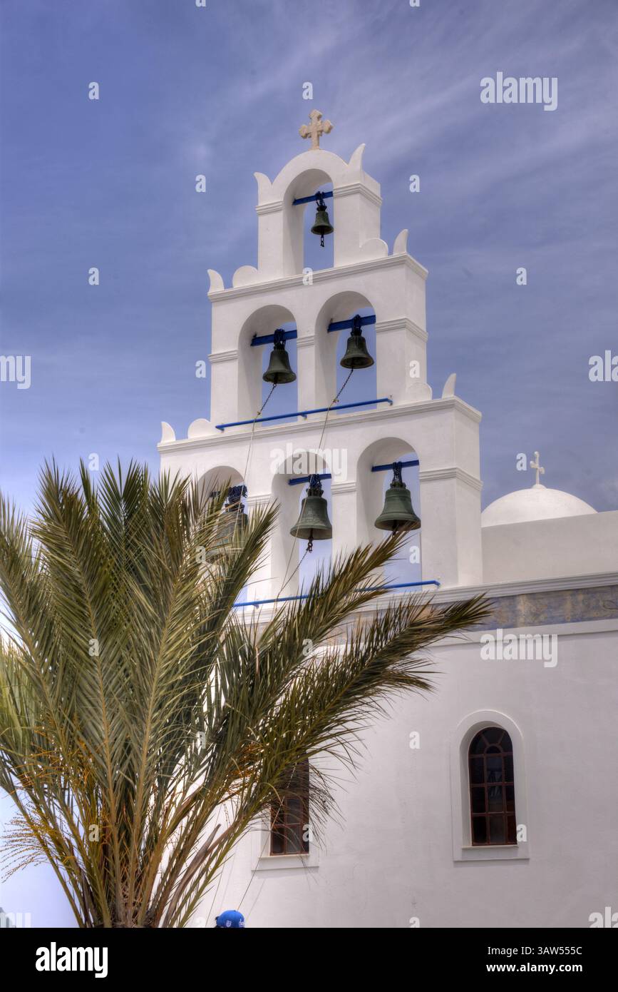 Weißer Kirchturm der Kirche von Agia Irini mit Palme in Oia auf der Insel Santorin. Stockfoto