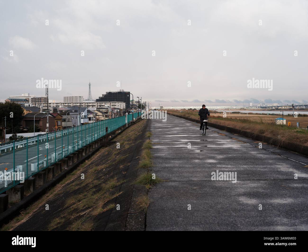 Tokyo Riverside Embankment Fahrradweg mit Pendlerradfahrern und nassem Riverside Path Stockfoto