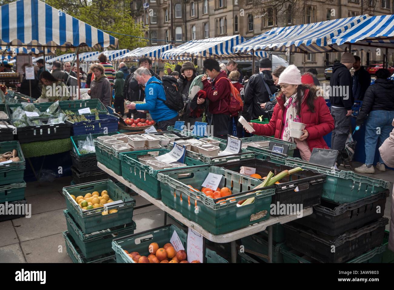 Käufer, die Obst und Gemüse auf dem Saturday Farmer's Market in Castle Terrace, Edinburgh, Schottland, Großbritannien auswählen. Stockfoto