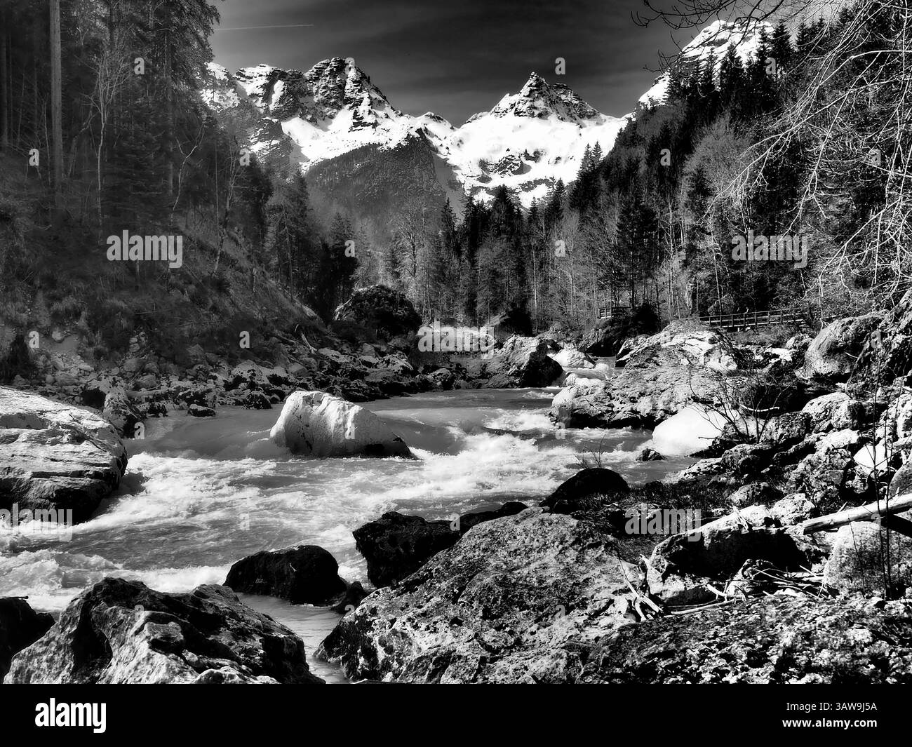 Bachlauf vor schneebedeckten Bergen im Salzburger Land Stockfoto