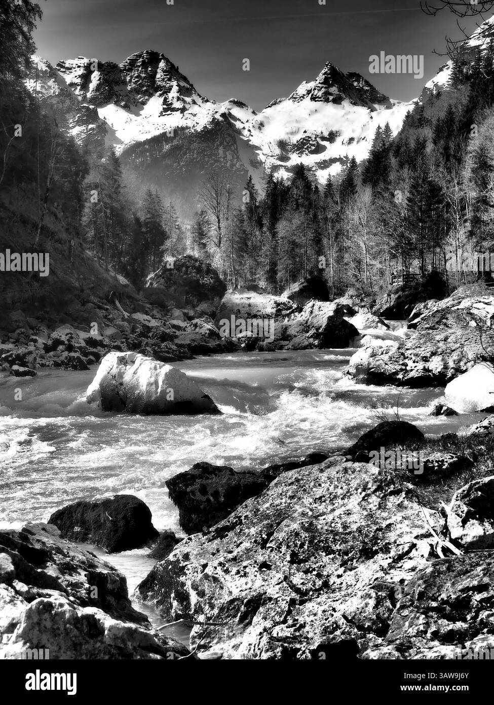 Bachlauf vor schneebedeckten Bergen im Salzburger Land Stockfoto