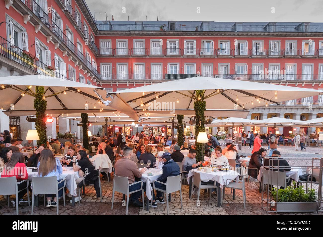 Leute, die draußen in Restaurants auf der Plaza Mayor in Madrid sitzen Stockfoto