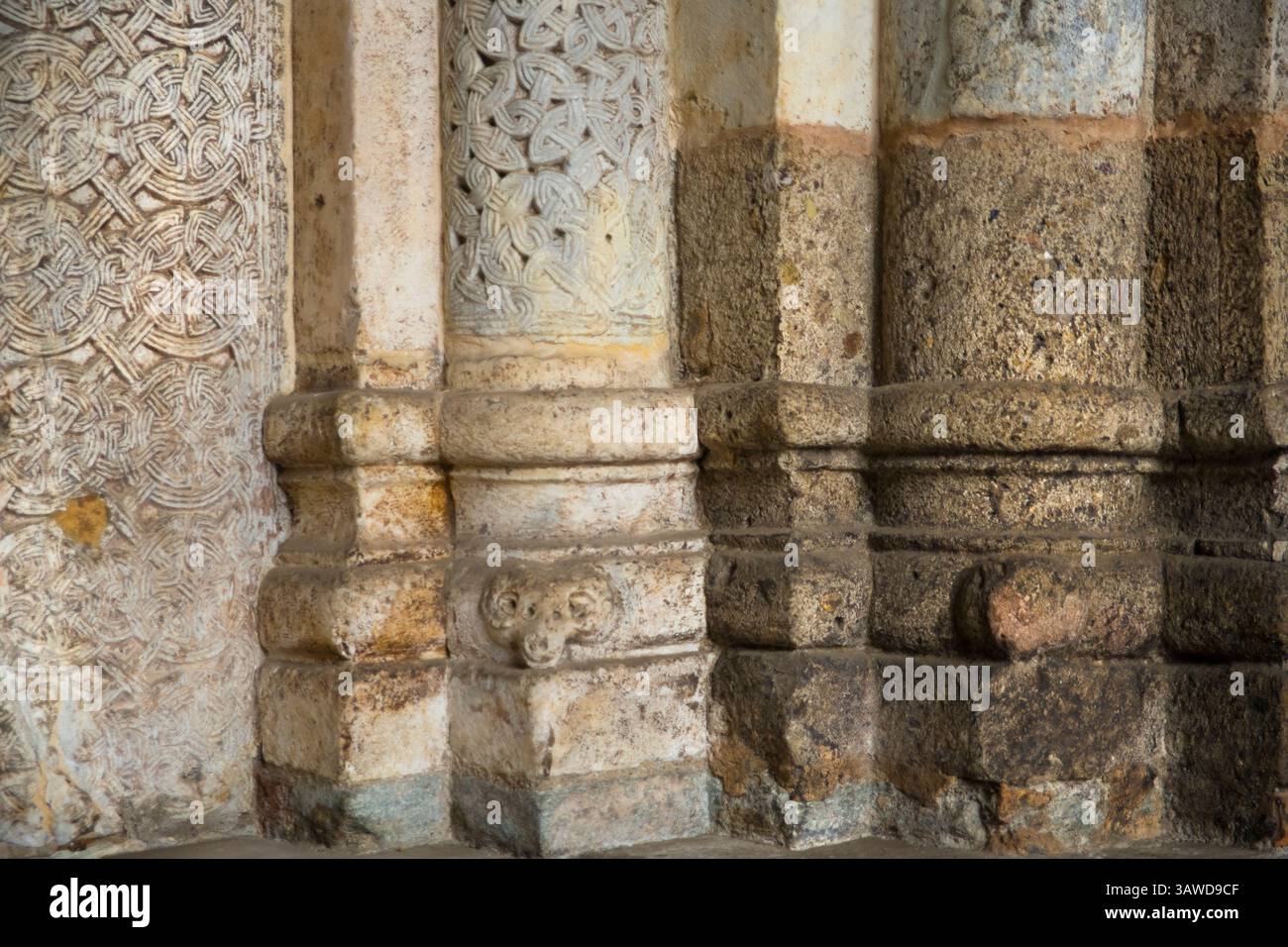 Detail aus Stein gemauertem Mauerwerk an der Außenseite der Basilika Sant'Ambrogio, Mailand, Italien. Steinsäulen mit geometrischen Designs Stockfoto