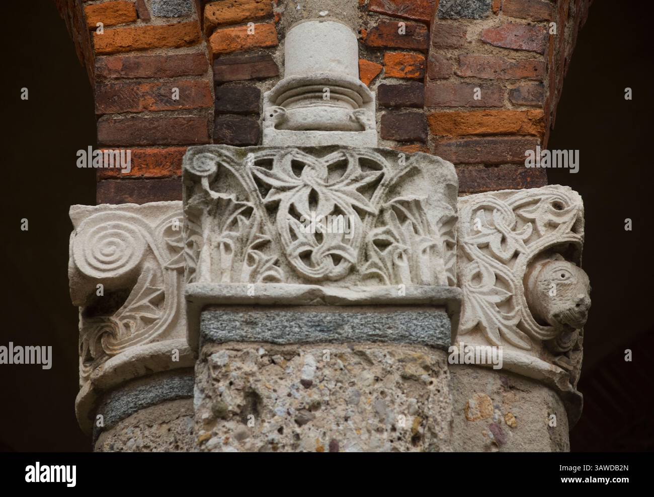 Detail aus Stein gemauertem Mauerwerk an der Außenseite der Basilika Sant'Ambrogio, Mailand, Italien. Steinsäulen mit stilisierten Tiermotiven Stockfoto